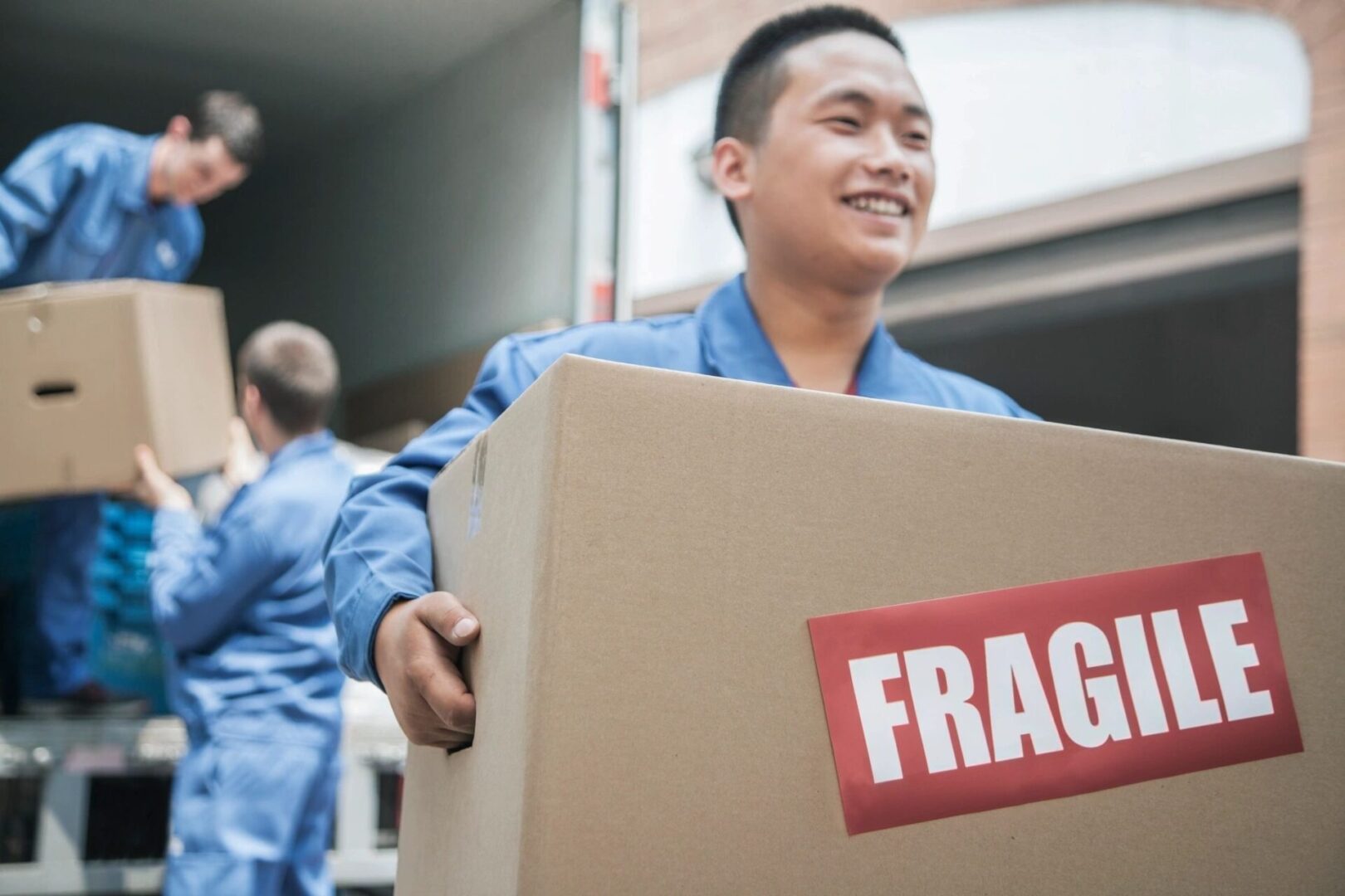 A man holding a box with the word fragile on it.