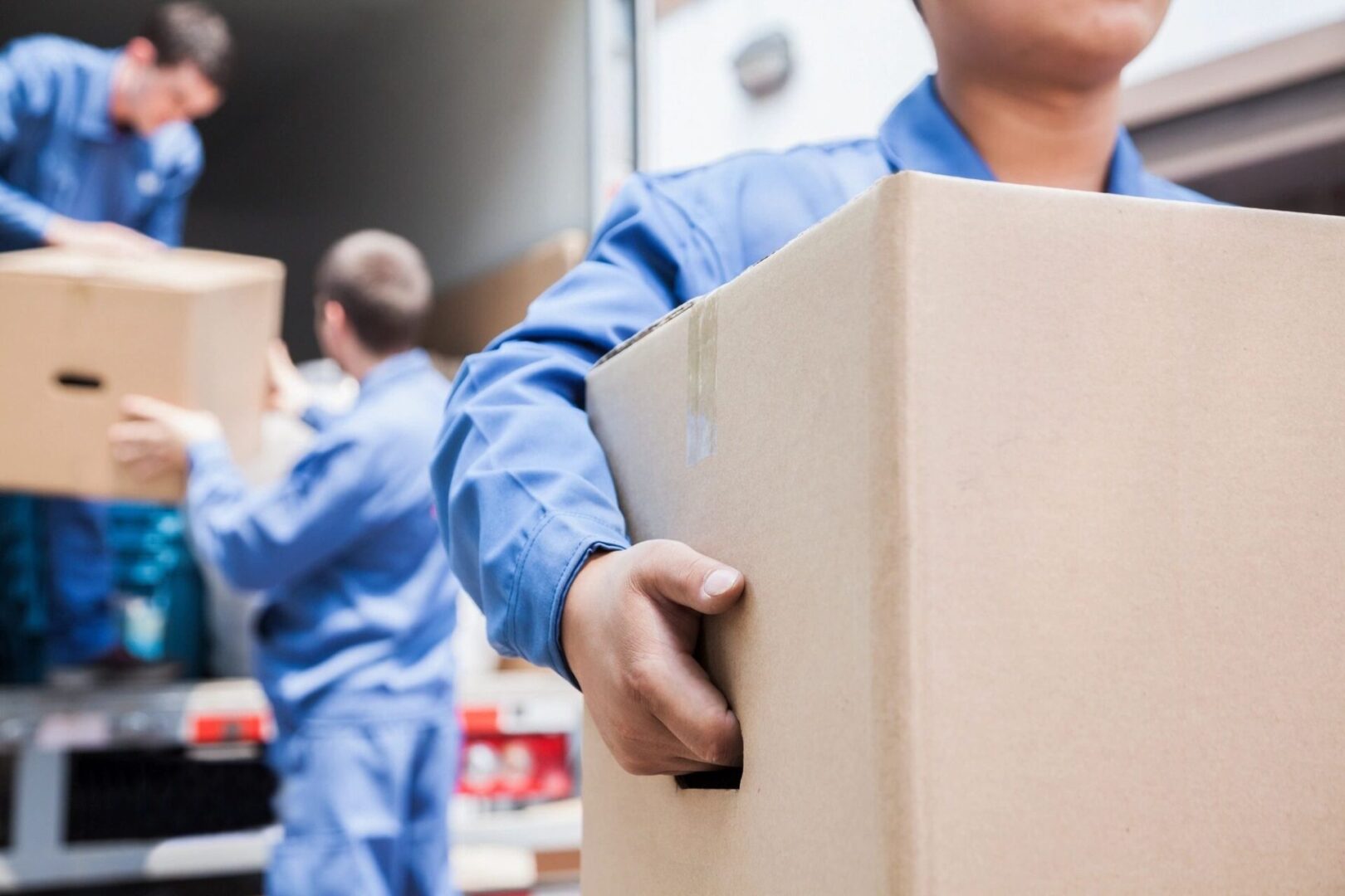 A man holding a box in front of another person.