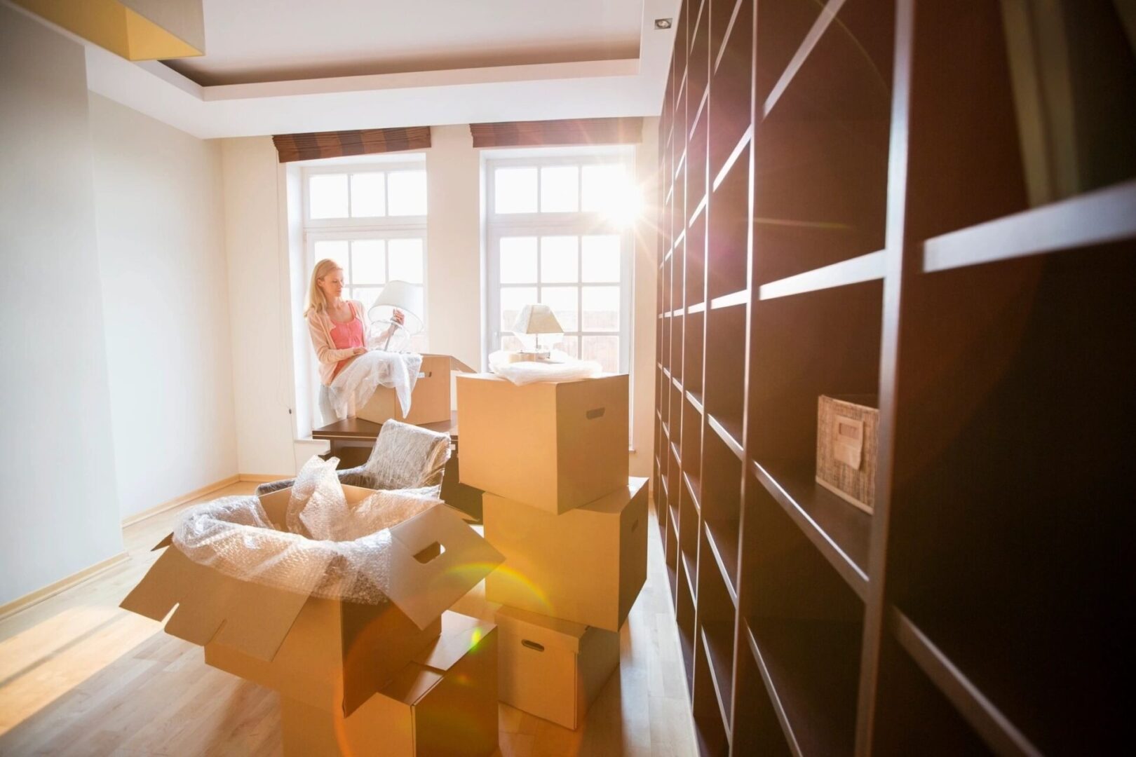 A woman standing in front of boxes on the floor.